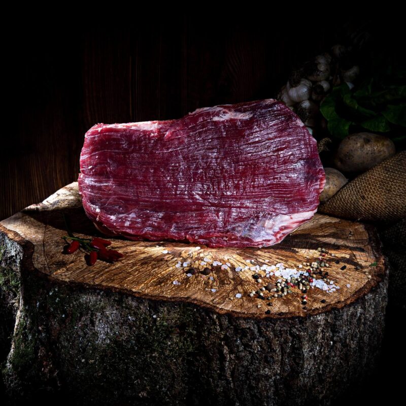 Rohes Flanksteak auf Holzscheibe