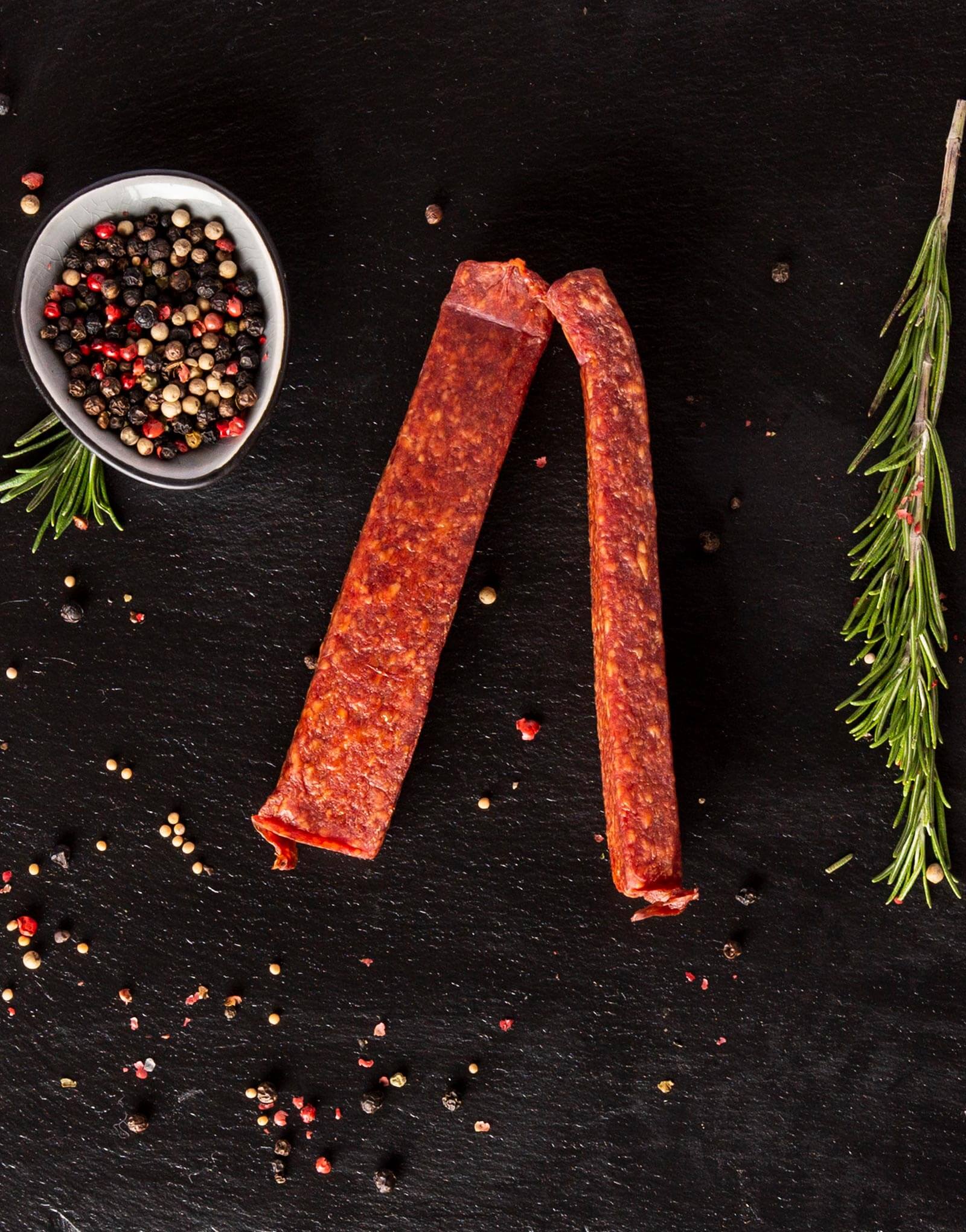 Wurst, Pfeffer, Kräuter, schwarzer Hintergrund